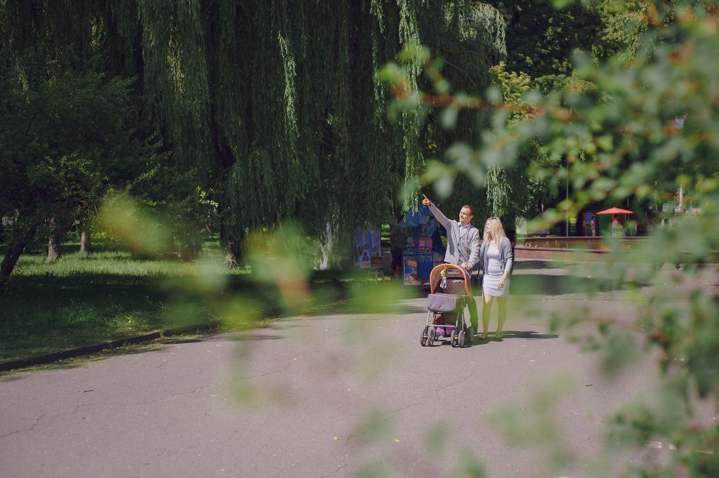 A person slipping on a wet park pathway while another visitor rushes to help, illustrating a potential public park injury due to unsafe conditions.